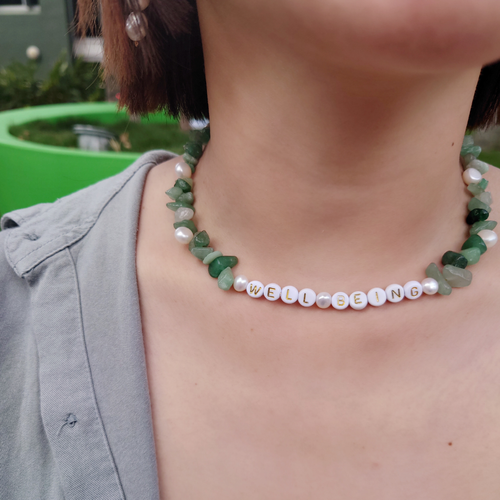 Girl wearing natural aventurine necklace with WELL-BEING bespoke beads